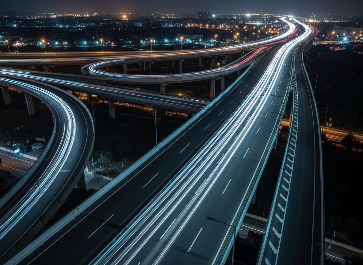 A minimalist, elevated highway interchange at night viewed from above, rendered in photographic realism, where multiple dark, smooth lanes converge into a single, clearly illuminated route. Tiny, sleek vehicles appear only as soft streaks of white and cool blue light, emphasizing flow rather than drivers. Carefully placed LED-style road lighting casts clean, symmetrical highlights and long, gentle shadows along the primary path, while side routes are dimmer and less defined. The composition uses sweeping curves and strong leading lines, with the main route framed on the rule of thirds, drawing the eye toward a bright, clear horizon. The mood is composed, decisive, and reassuring, suggesting complex choices resolved into one confident direction without relying on clichéd business visuals.